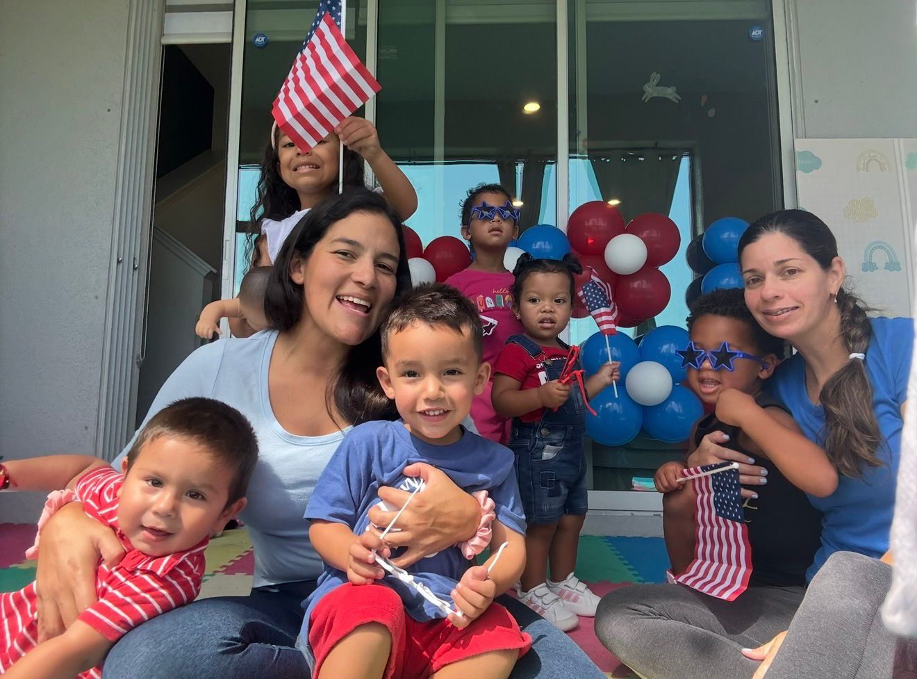 Children and teachers celebrating with American flags and balloons