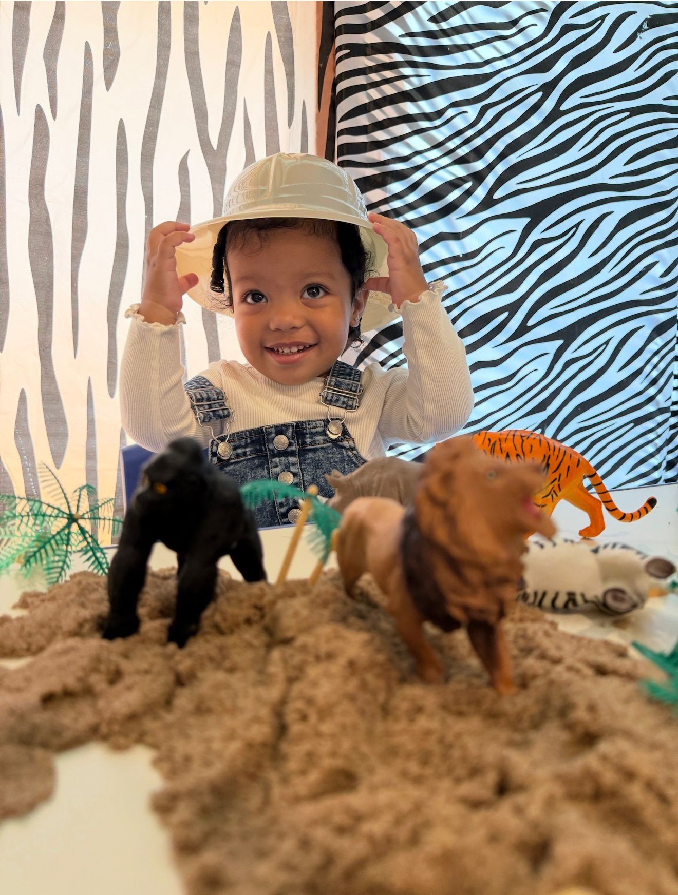 Toddler exploring a safari-themed sensory play scene